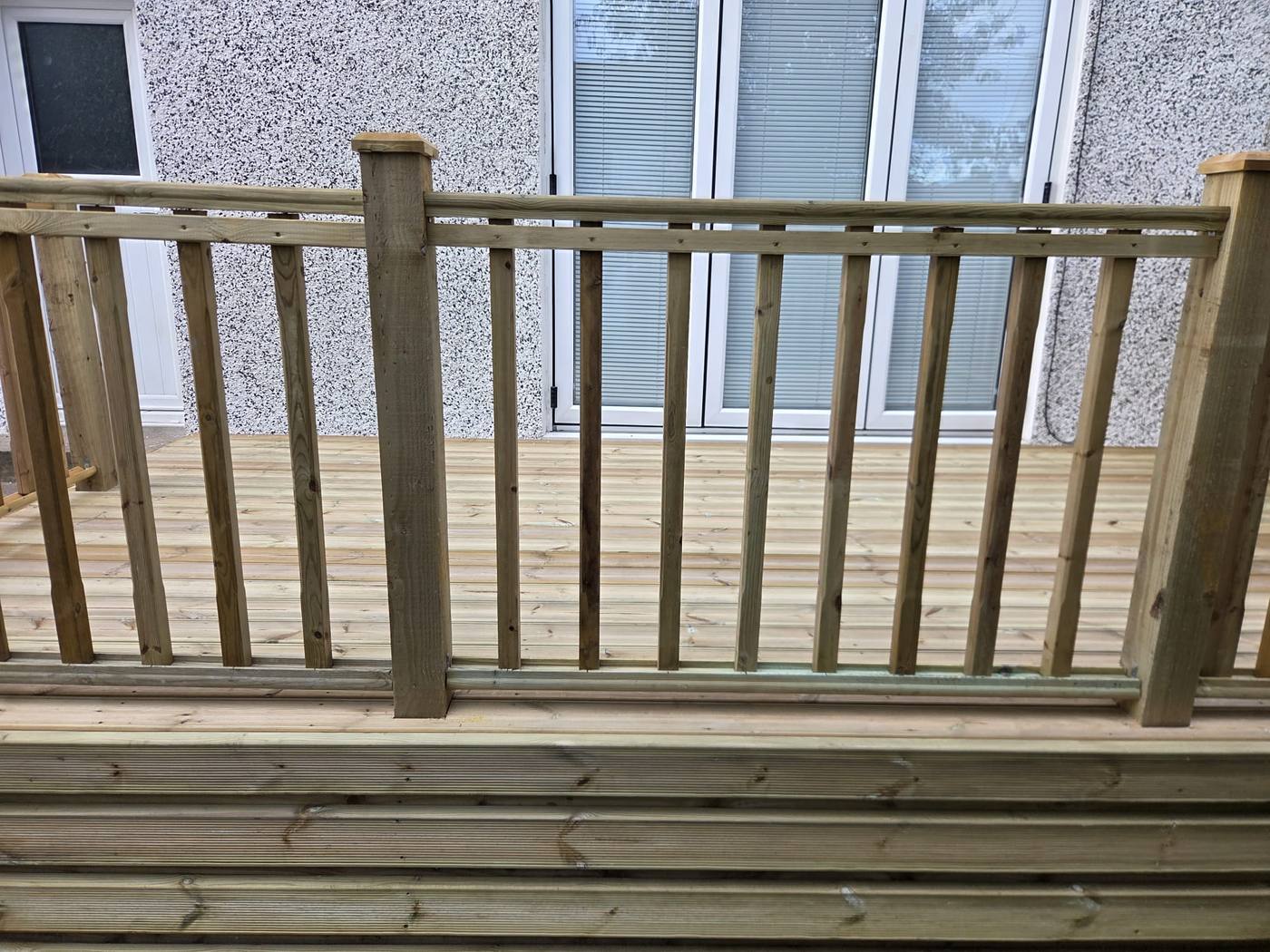 Spindle balustrade and handrail along the edge of a new timber deck