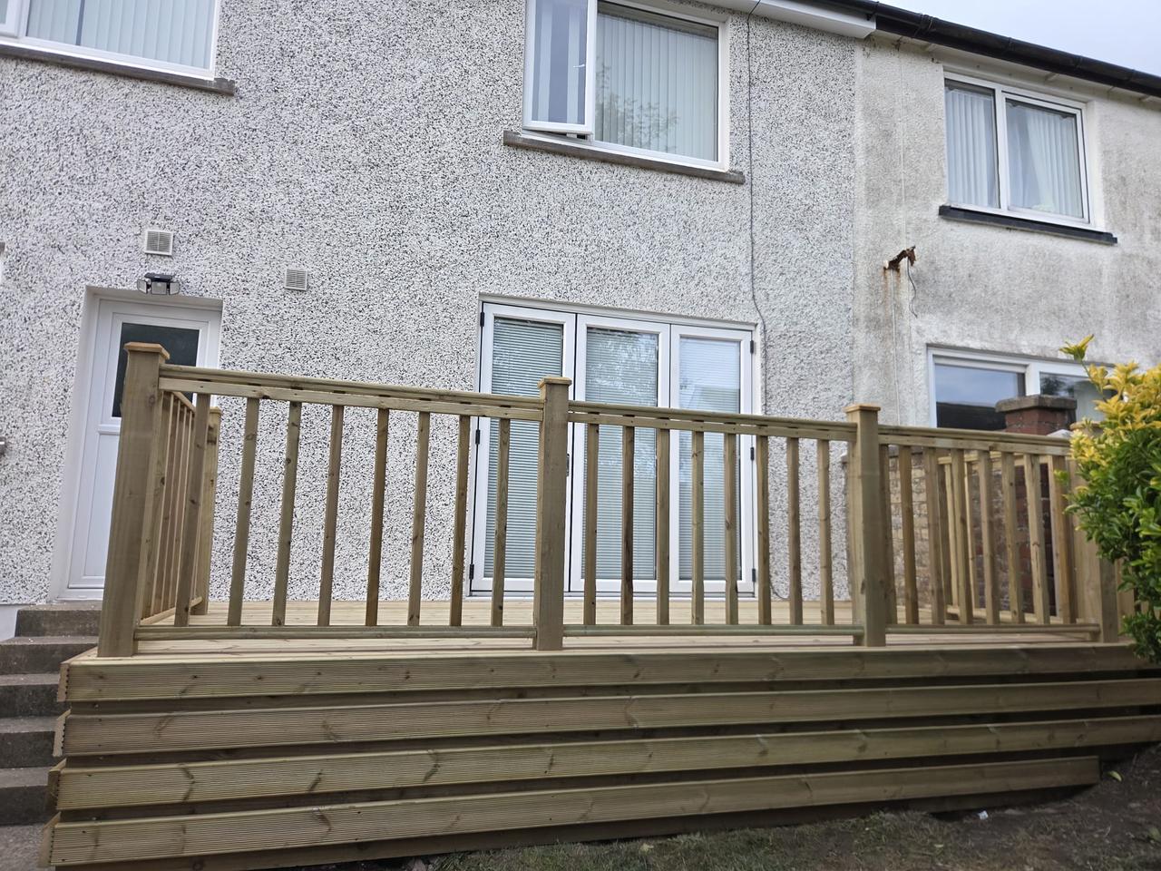 Raised timber deck with a spindle balustrade across the back of a house, West Lakes Fencing work near market square, Millom LA18