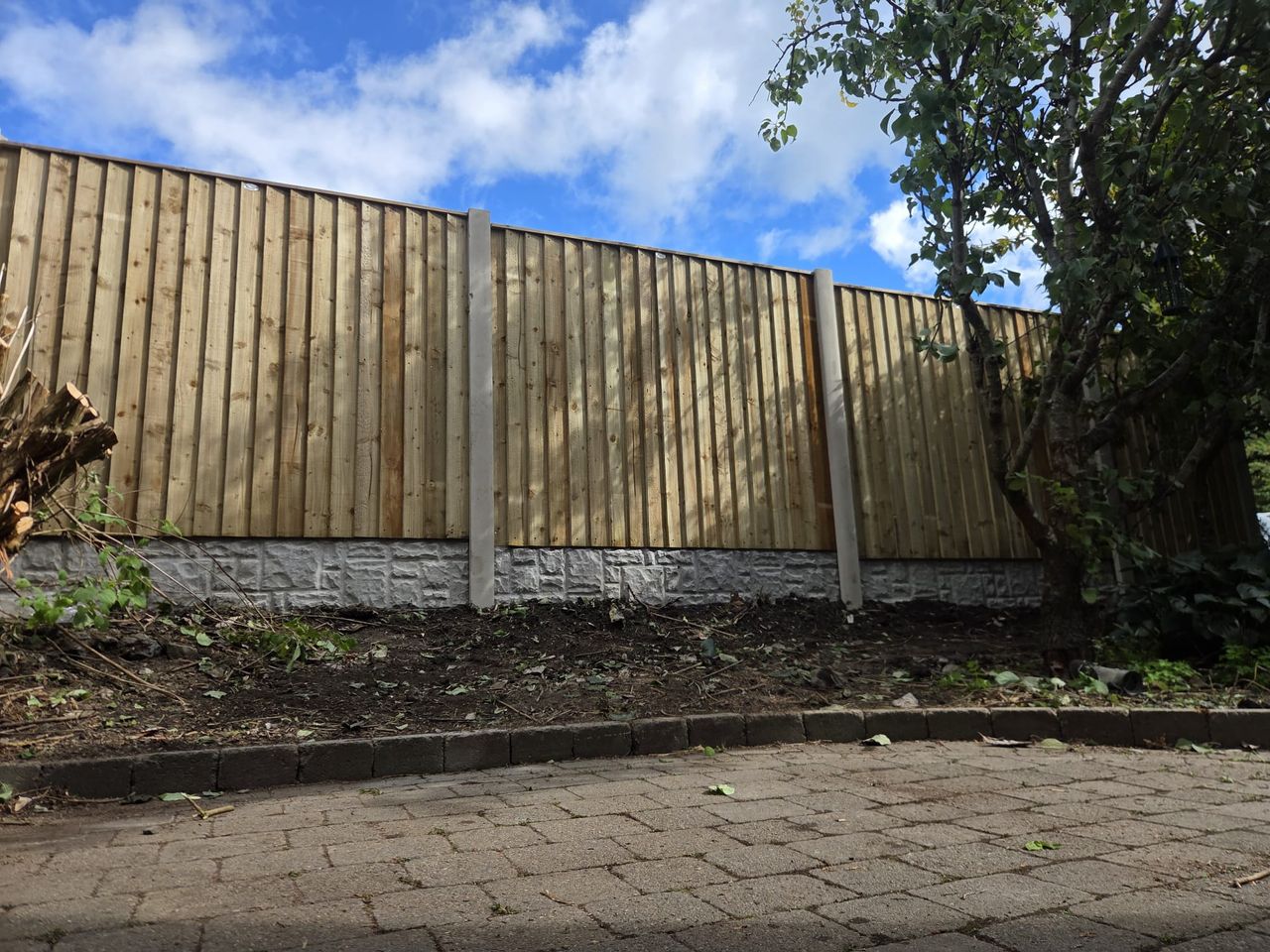 New featheredge fence run on concrete posts with rock-faced gravel boards